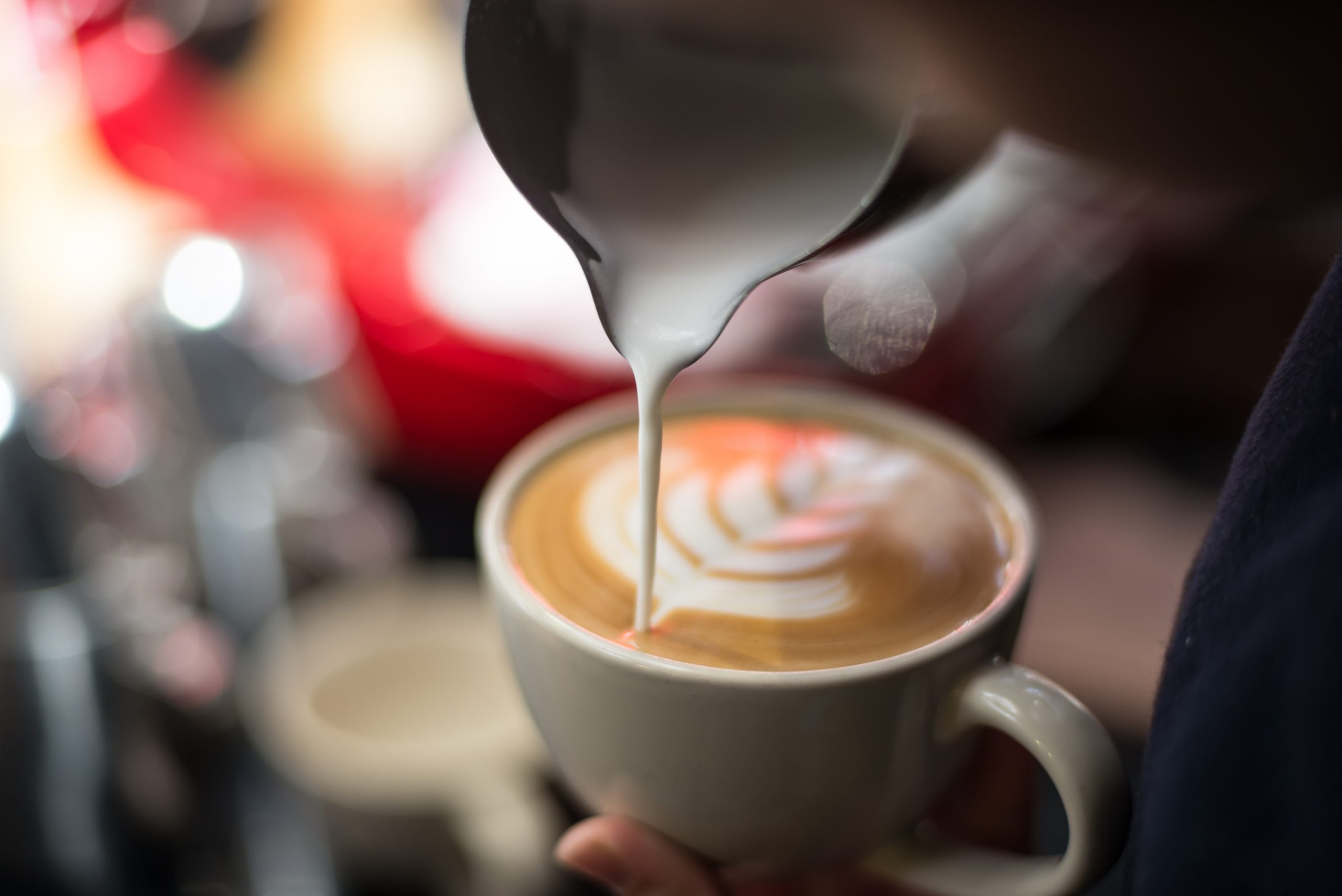 Hombre haciendo un café latte o un cappuccino con un dibujo